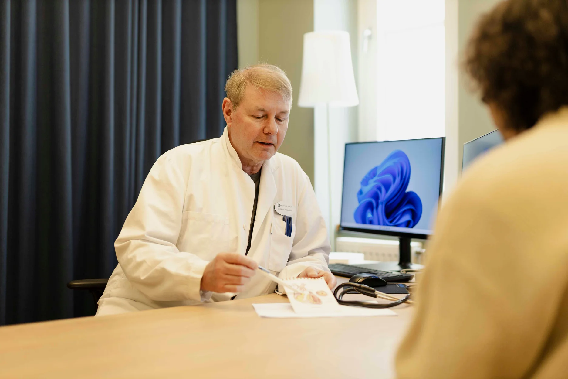Doctor at Executive Health reviewing examination results with a patient.