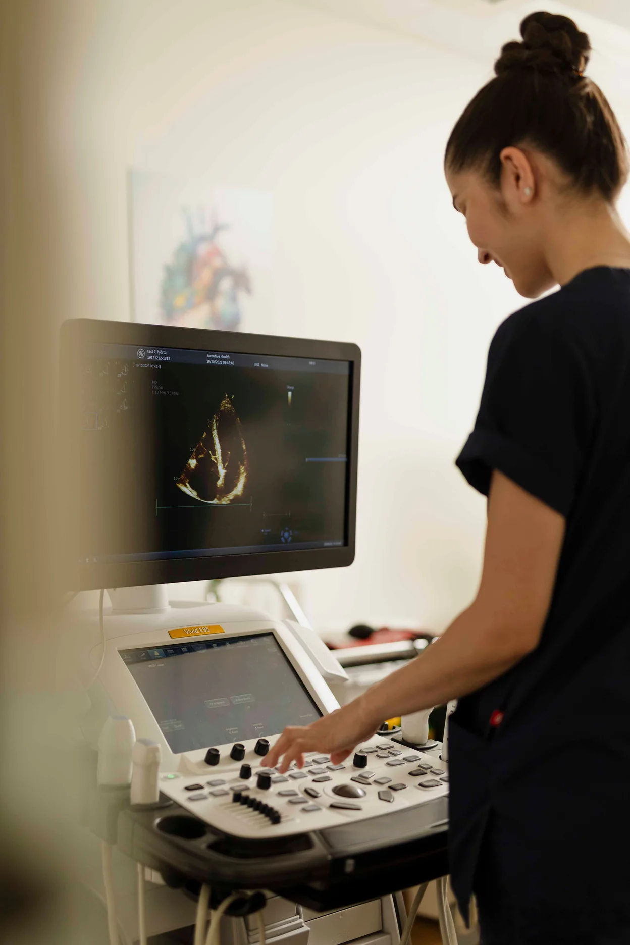 Clinician operating echocardiography equipment during an advanced health examination.