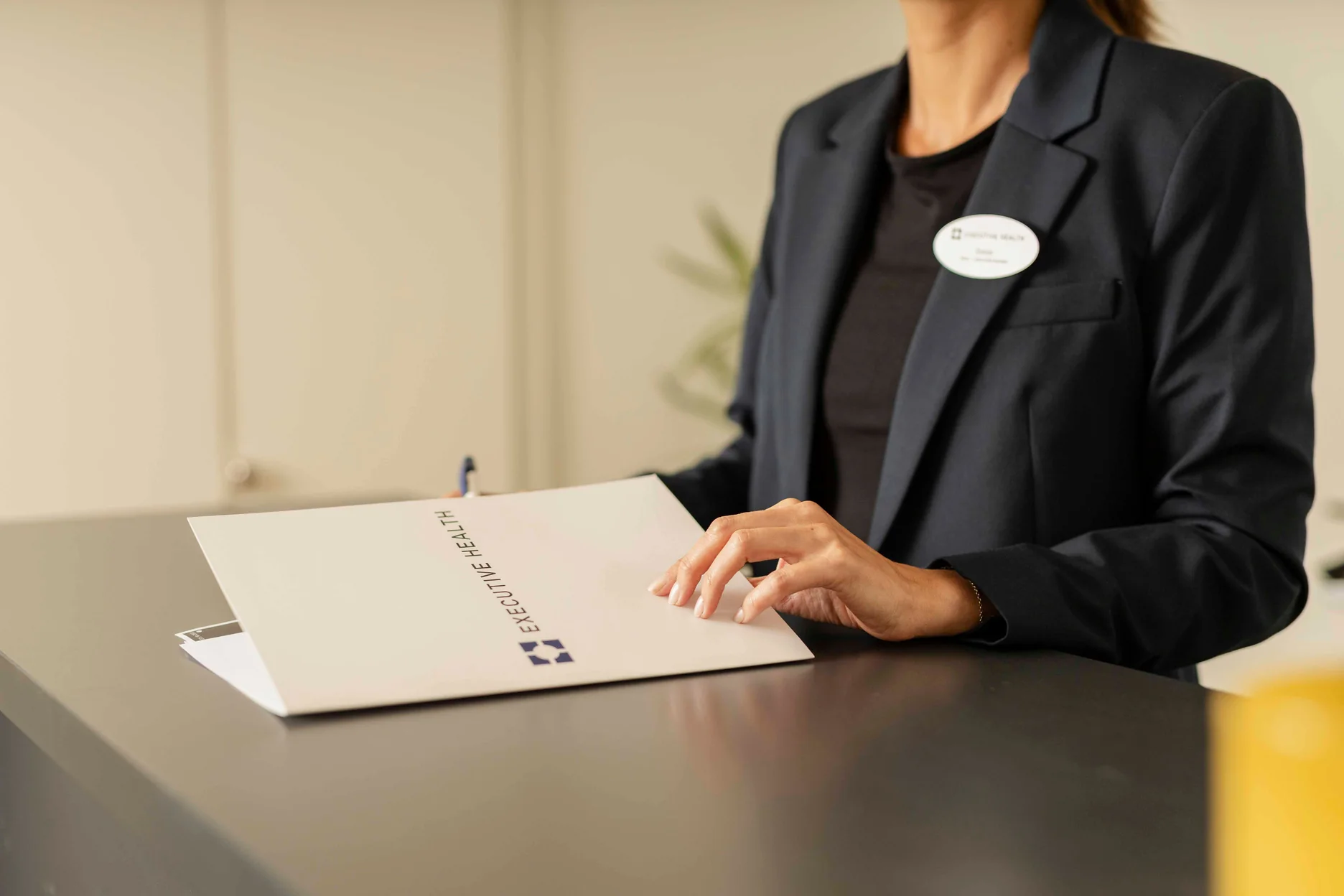 Executive Health staff reviewing a patient document during the reception process.